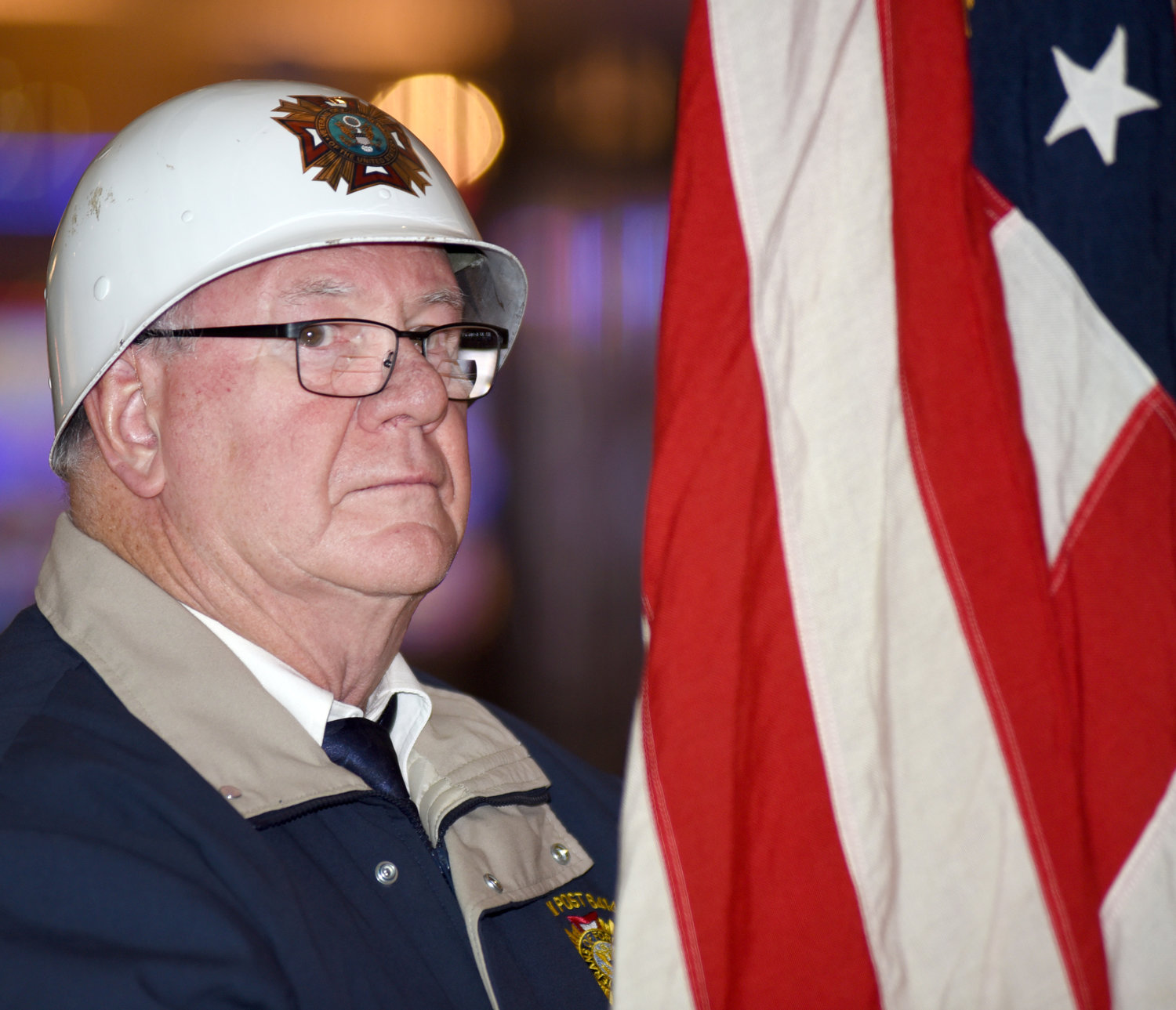 Ed Mattes from the Riverside VFW Post No. 6414 holds the American flag during Veterans Day ceremonies at the Riverside Casino on Monday. The ceremony moved inside due to the snow and cold. The indoors ceremony concluded with the playing of Lee Greenwood’s “I am Proud to be an American.” Several of the veterans in the audience stood and saluted during the song. The slot machines in the casino fell silent as casino customers moved toward the ceremony in the casino’s entrance, some wiping away tears as the song played.